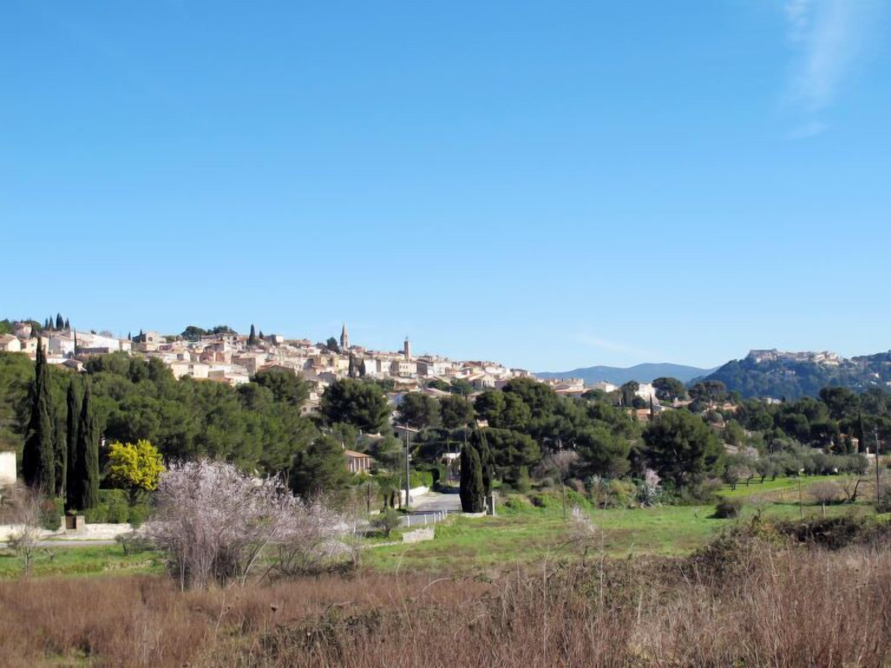 Un pueblo con edificios históricos y una fortaleza en la cima de una colina.