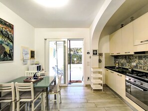 Una cuina moderna amb una illa gran, armaris blancs i un salvasillons revestit de rajoles.