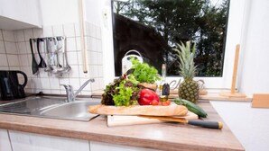 Una cucina con un piano di lavoro in legno, un lavello e diversi utensili da cucina.