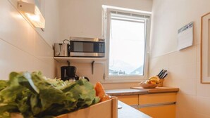 Une cuisine équipée d’un four à micro-ondes, d’une machine à café et d’une fenêtre.