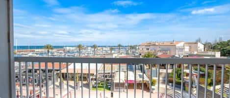 A balcony with a view of a marina and buildings.