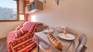 Een gezellige kamer met een bed, een ontbijttafel en een raam met uitzicht.