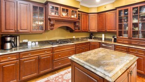 A kitchen with wooden cabinets, a granite countertop, and a built-in stove.