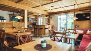 A cozy, wooden-furnished restaurant with multiple seating areas, including tables and a sofa. - Apartment Ladis by Interhome (Fiss)
