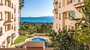 Un resort con piscina, vegetazione e vista sul mare.