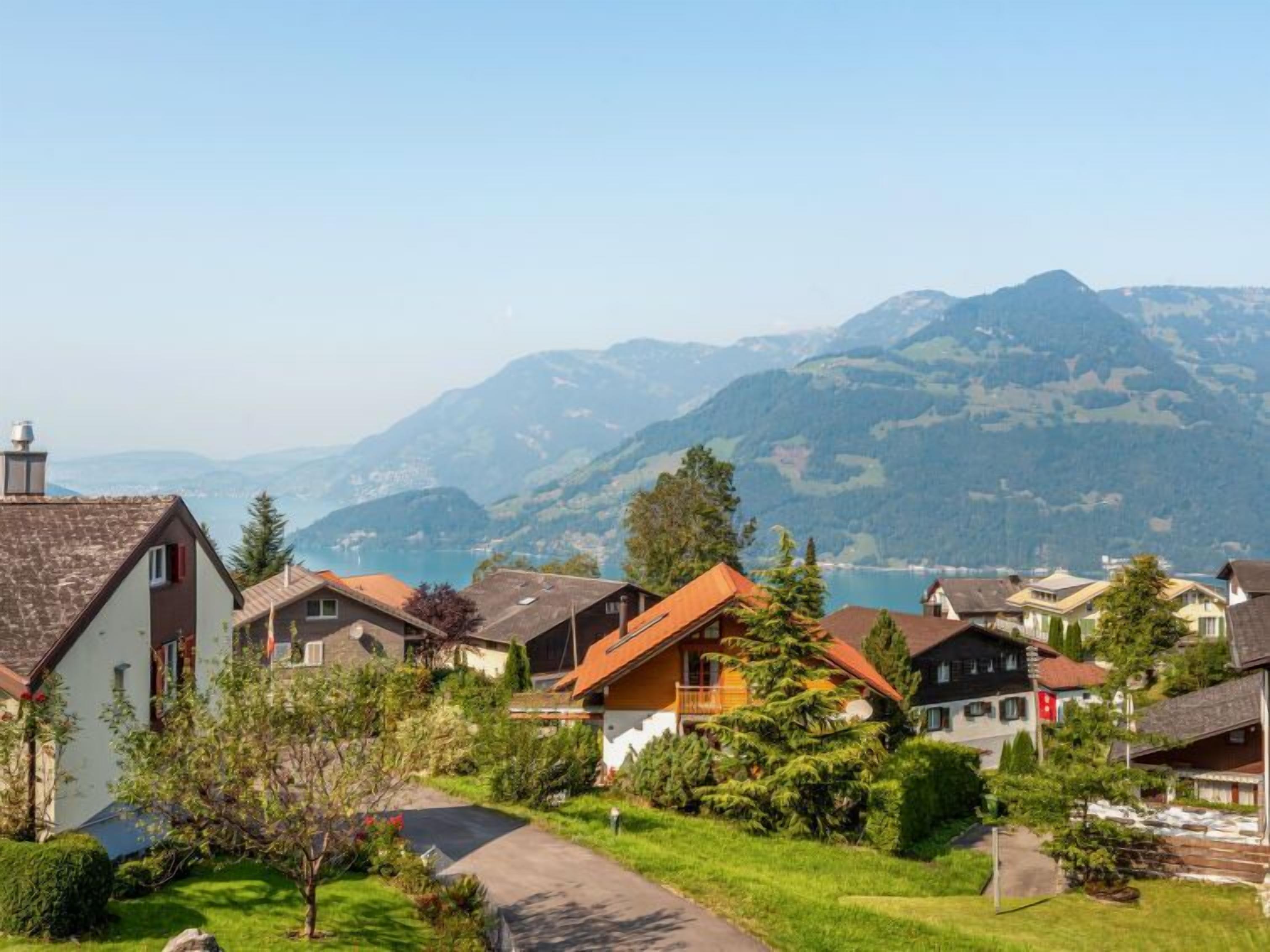 Um bairro residencial com casas, um caminho e montanhas ao fundo.
