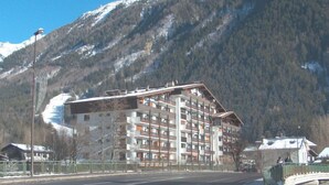 A multi-story hotel with balconies, set against a mountainous backdrop. - Les Periades by Interhome (Chamonix)