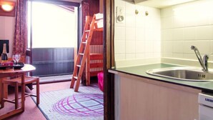 A compact kitchen with a sink, cabinets, and a wooden ladder. - Les Periades by Interhome (Chamonix)