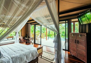 A bedroom with a bed, a wooden desk, and a television.
