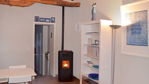 Een gezellige kamer met een open haard, een boekenkast en een eethoek.
