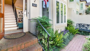 Una casa residencial con una escalera que lleva a una puerta, un buzón y un cartel con el número 525.