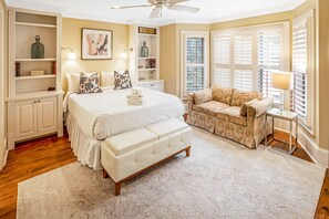 A bedroom with a large bed, a sofa, a side table, and a window with blinds. - Broughton Street Villa with Rooftop Terrace, Garage Parking by Lucky Savannah (Savannah)