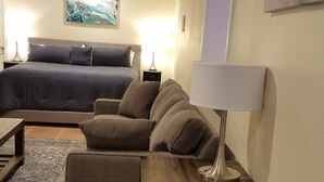 Moderni olohuone, jossa on sohvaryhmä, sohvapöytä ja lamppu.