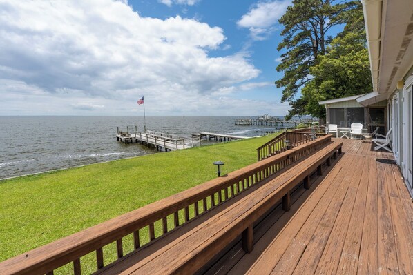 A wooden deck with a view of the ocean and a dock extending into the water. - Waveney Cottage in Point Harbor Soundfront 2 Bedroom Home w/ Private Pier (Point Harbor)