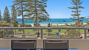 A balcony with a view of the beach and ocean, featuring outdoor seating and traffic lights. - Blue C 305 - Beachfront Coolangatta - Min. 3 Night Stays! (Coolangatta)