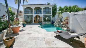 A modern house with a swimming pool, surrounded by potted plants and a lounge chair. - Vittoria (6 bedrooms) - Beachfront villa, Simpson Bay, St. Maarten (Simpson Bay)