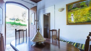 Uma área de refeições com mesa de madeira, cadeiras e um abajur decorativo.