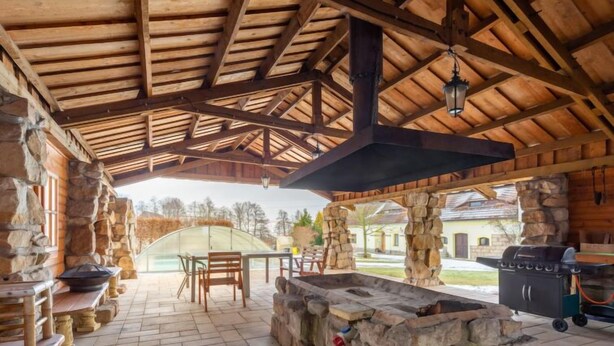 Eine Terrassengruppe mit Steinmauern, Holzboden und Grillplatz.