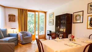 Un comedor con una mesa dispuesta para cuatro personas, un sofá y un aparador.