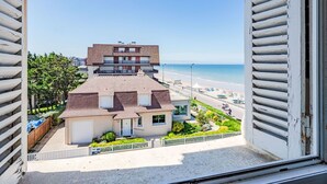 Un immeuble de deux étages doté d’un balcon donnant sur une plage.
