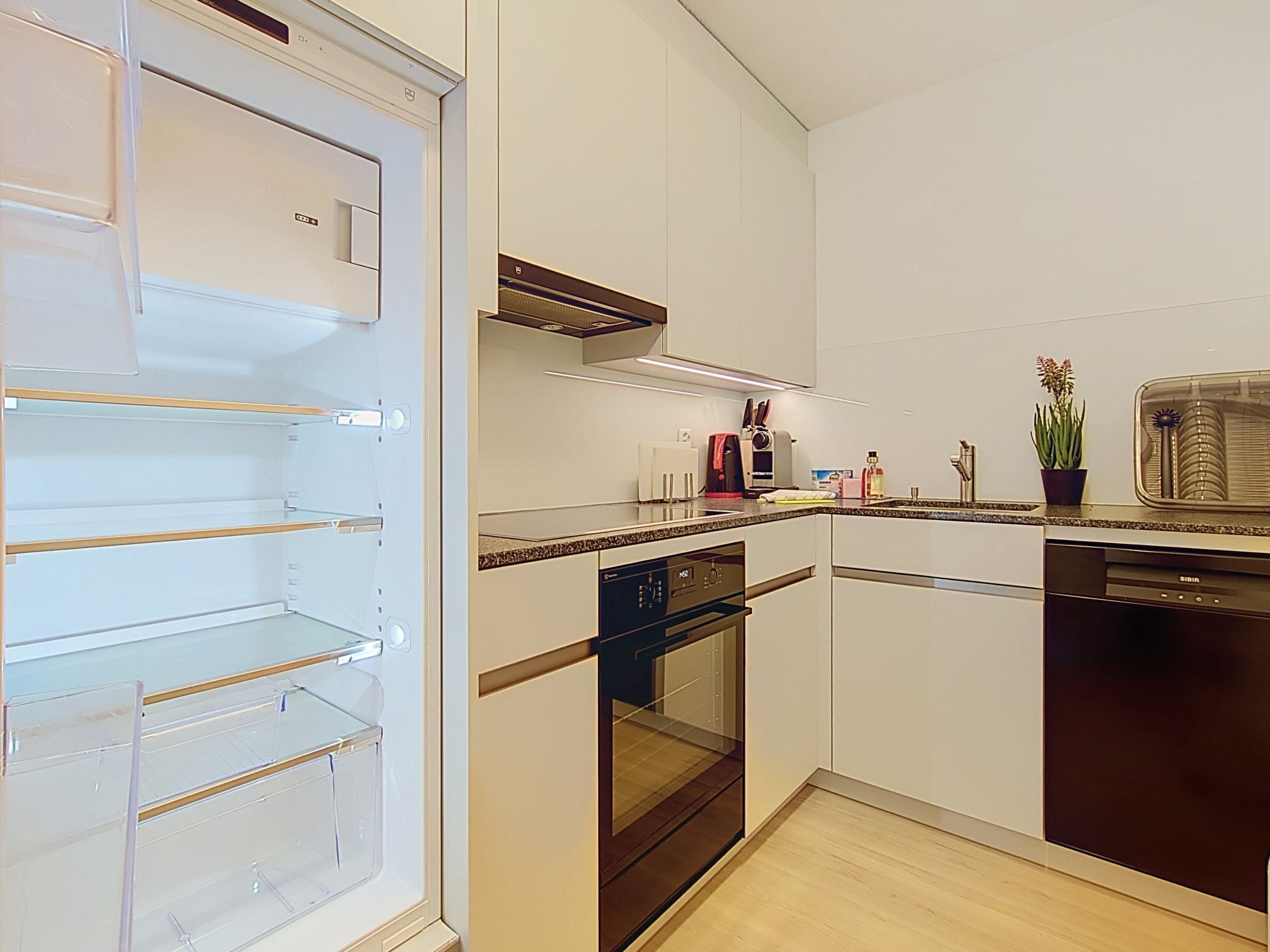 A modern kitchen with a built-in oven, a dishwasher, and a microwave.