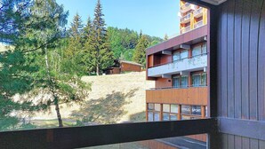 Ein Balkon mit Tisch, Stuhl und einer Servitasse mit Brot.