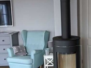 A room with a sofa, a small table, and a fireplace. - Vacation home Ankerplatz for rent in the Baltic seaside resort of Rerik - Holiday home Ankerplatz (Rerik (Ostseebad))