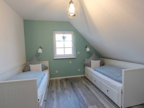 A room with two single beds, a window, and a light fixture. - Vacation home Ankerplatz for rent in the Baltic seaside resort of Rerik - Holiday home Ankerplatz (Rerik (Ostseebad))