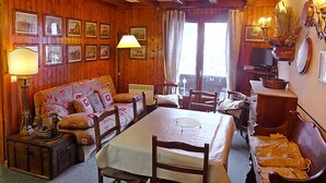 Une pièce chaleureuse avec des murs en bois, un canapé, une table et un téléviseur.