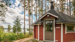 A small red cabin with a chimney, a door, and a window.