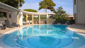 A swimming pool with lounge chairs and a covered seating area. - Appartamento 2 by Interhome (Terracina)