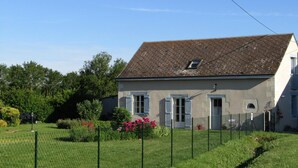 A two-story house with a sloped roof, a small dormer window, and a front door. - Comfortable cottage with large private garden and WIFI (Channay-sur-Lathan)
