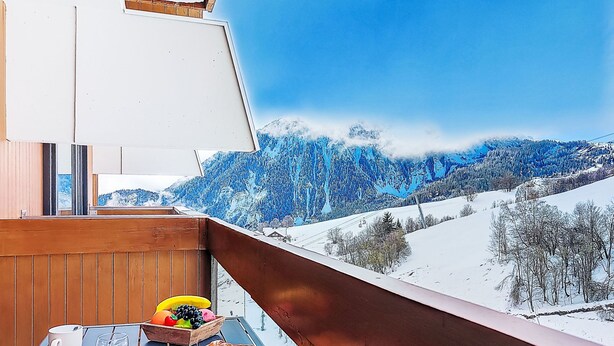A balcony with a wooden railing overlooking a snowy mountain landscape. - Vostok Zodiaque by Interhome (Le Corbier)