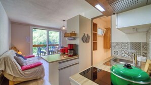 A compact room with a bed, a dining area, and a kitchenette. - Vostok Zodiaque by Interhome (Le Corbier)