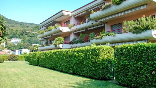 Un hotel de varios pisos con balcones, cada uno decorado con plantas.
