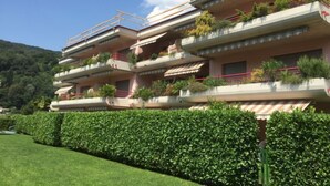 Un edificio residencial de varios pisos con balcones, algunos con plantas.
