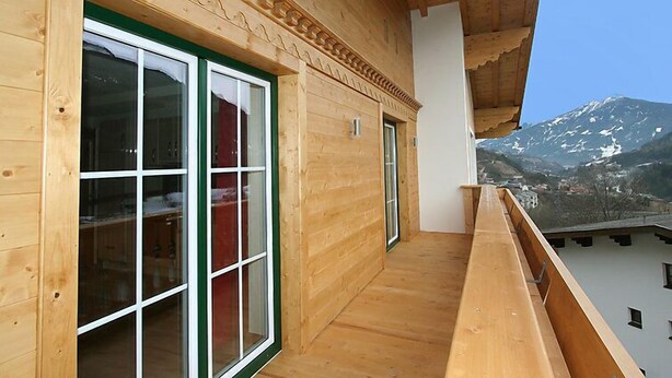 A wooden building with large windows and a balcony overlooking a mountain. - Pfeifer by Interhome (Pians)