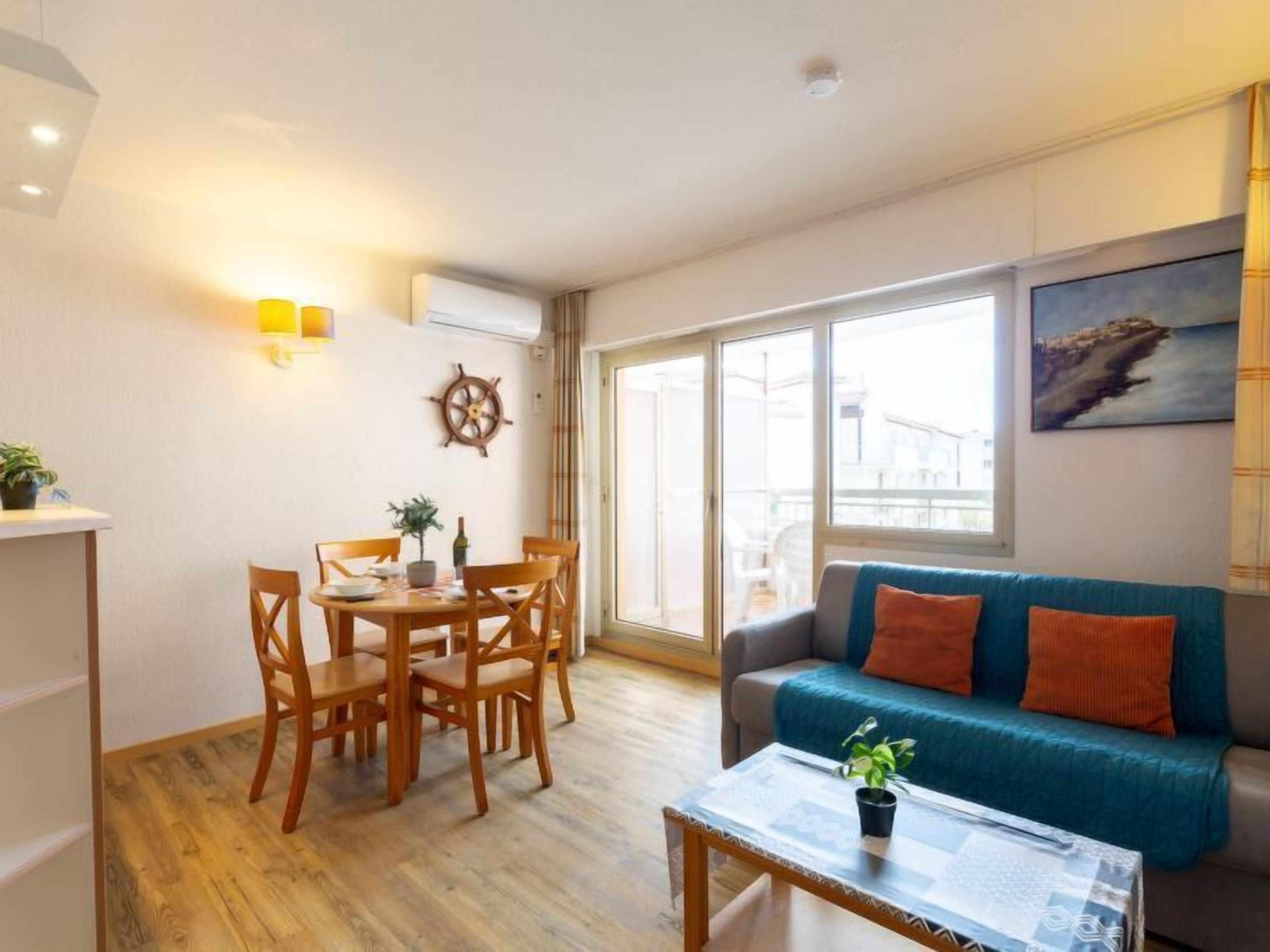 Een woonkamer met een eettafel, stoelen, een bank en een salontafel.