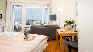 Een hotelkamer met een bed, een bank, een eettafel en een televisie.