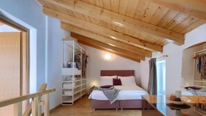 A bedroom with a wooden ceiling, a bed with white bedding, a bedside table, and a wardrobe. - Vacation home Ana by Interhome (Rovinj/Rovinjsko Selo)