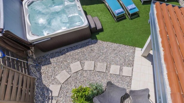 A hot tub surrounded by lounge chairs and a stone wall. - Vacation home Ana by Interhome (Rovinj/Rovinjsko Selo)