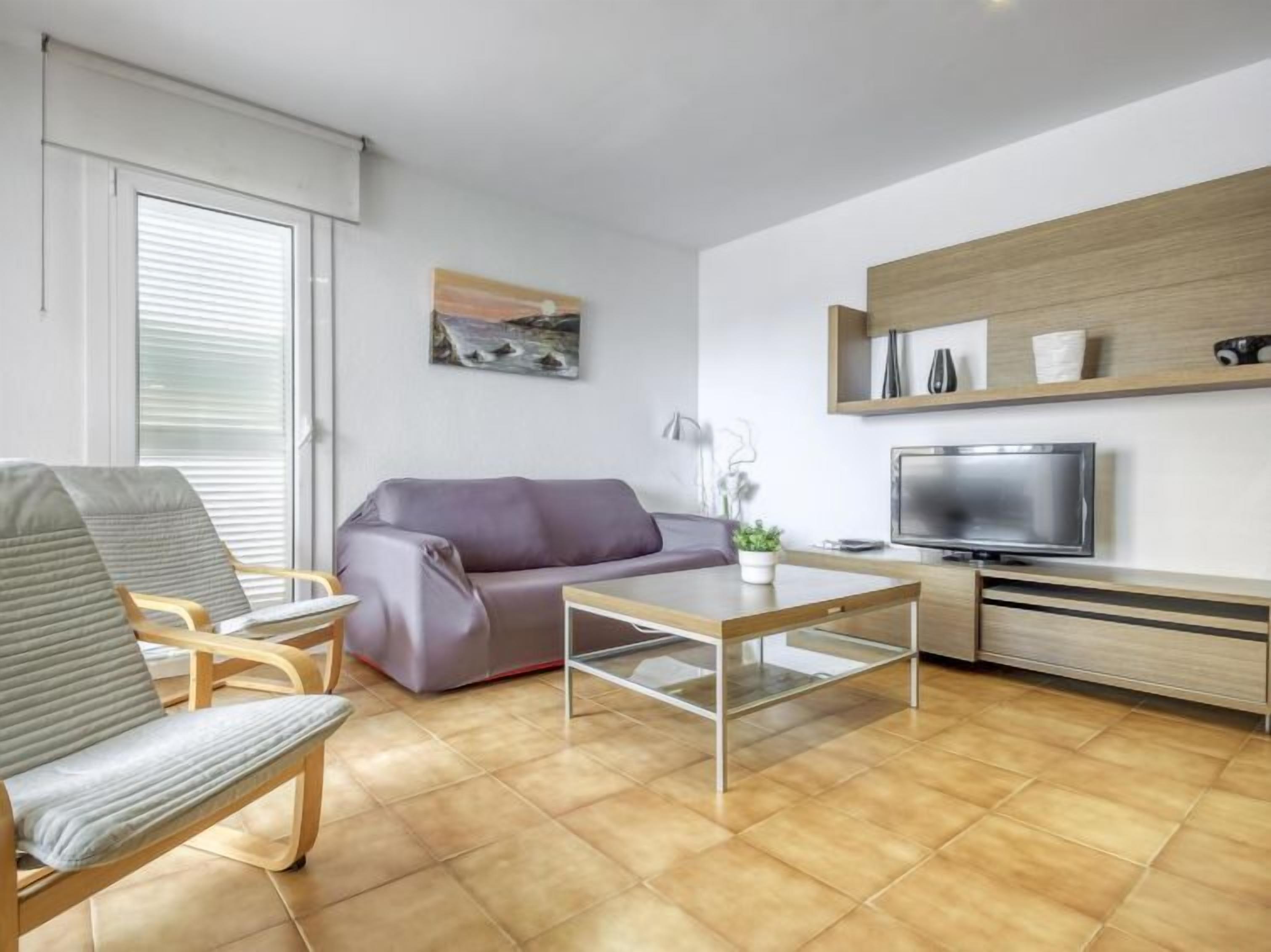A modern living room with a sofa, a chair, a coffee table, a TV, and a wooden cabinet.