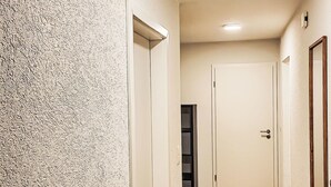 A hallway with textured walls, a wooden floor, and white doors. - Ringstrasse Apt 215 by Interhome (Leukerbad)