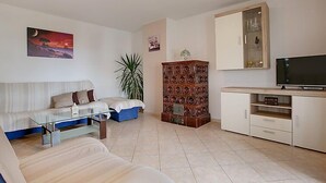 Ein Wohnzimmer mit einer Couch, einem Couchtisch, einem Fernseher und einem Schrank.