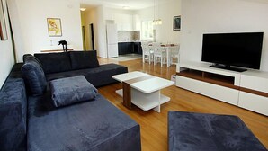 En moderne stue med sofa, sofabord og fjernsyn.