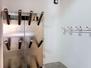 Un ascensor metálico con barandilla y perchero en la pared.
