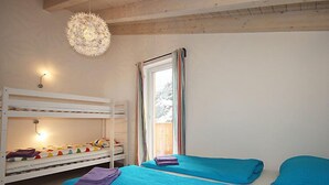 A room with bunk beds, a window with curtains, and a hanging light fixture. - am Arlberg by Interhome (Pettneu am Arlberg)