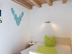 Un dormitorio con cama, lámpara de pared y un adorno mural.