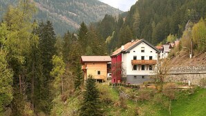 A mountain village with traditional wooden houses, surrounded by dense forest and mountains. - am Arlberg by Interhome (Pettneu am Arlberg)