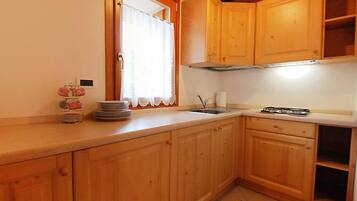 Køleskab, mikrobølgeovn, køkkentøj/tallerkener/redskaber, spisebord